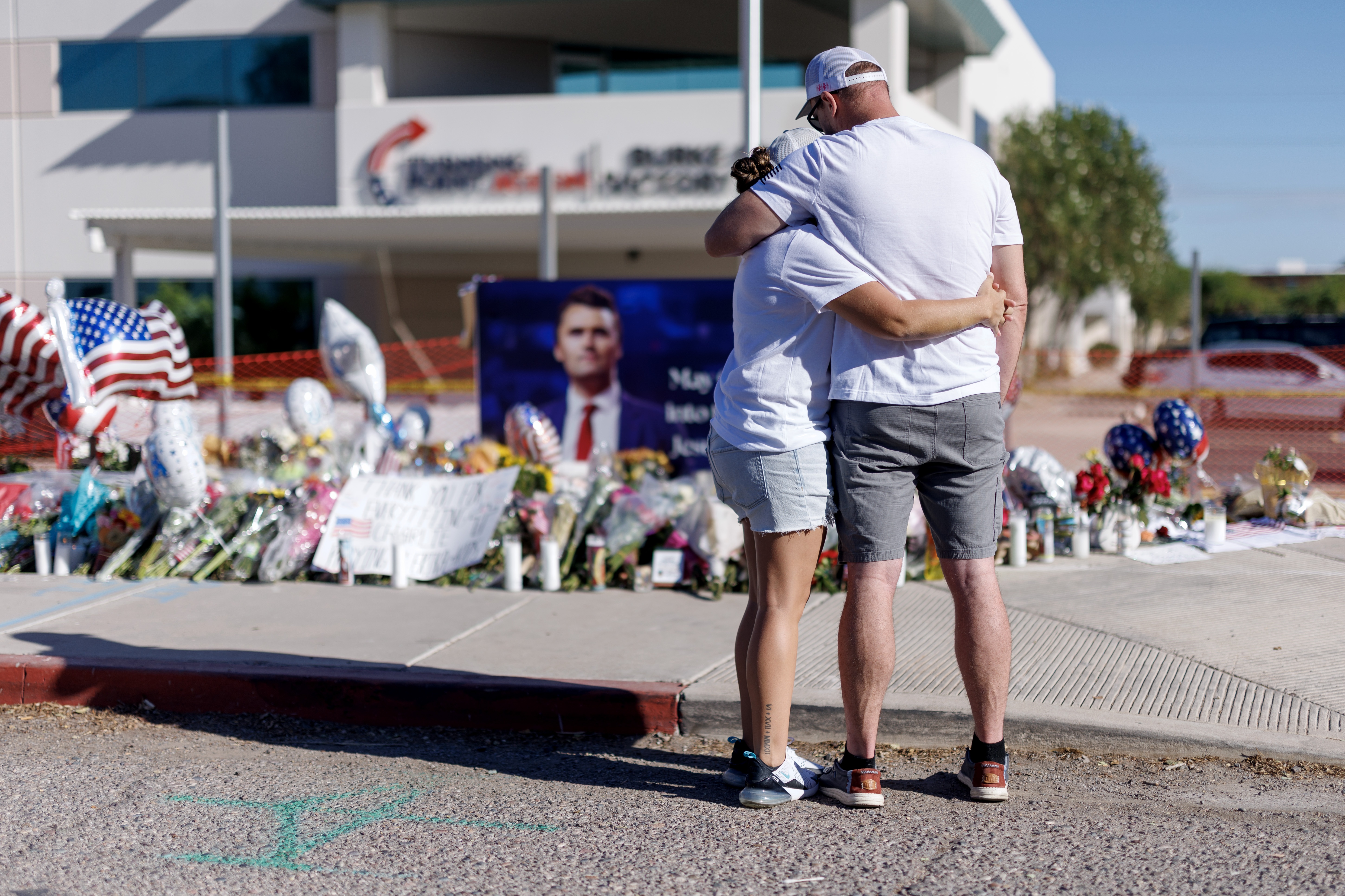 People embrace in front of a memorial for Charlie Kirk at the Turning Point USA headquarters on September 12, 2025 in Phoenix. Kirk, the CEO and co-founder of Turning Point USA, was shot and killed on Wednesday in Utah.