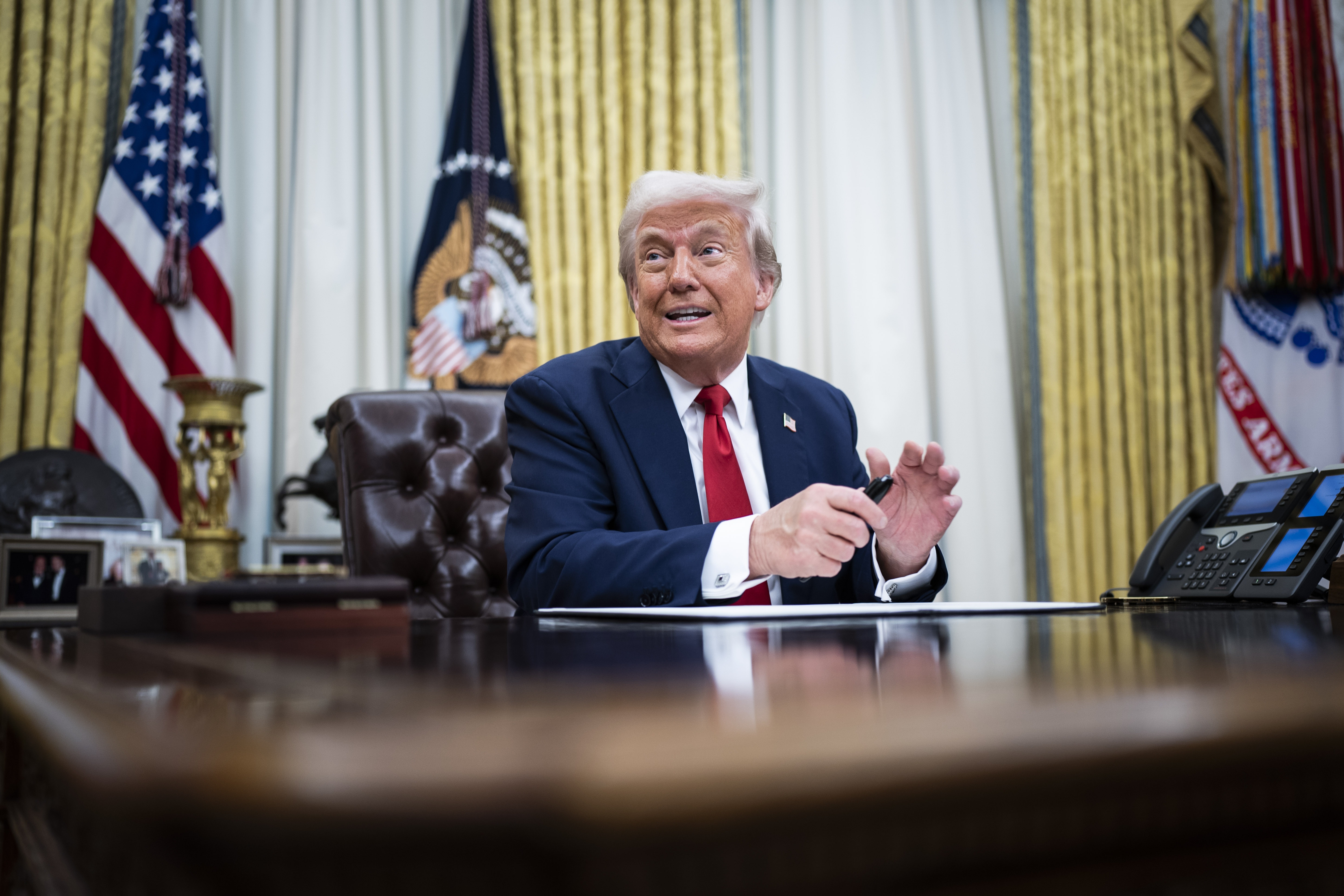 President Trump speaks to reporters and signs an executive order in the Oval Office on March 31.