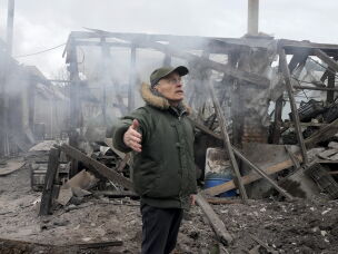 A man stands near a house destroyed in Russian artillery shelling in the Kyiv suburb of Horenka on March 6, 2022.