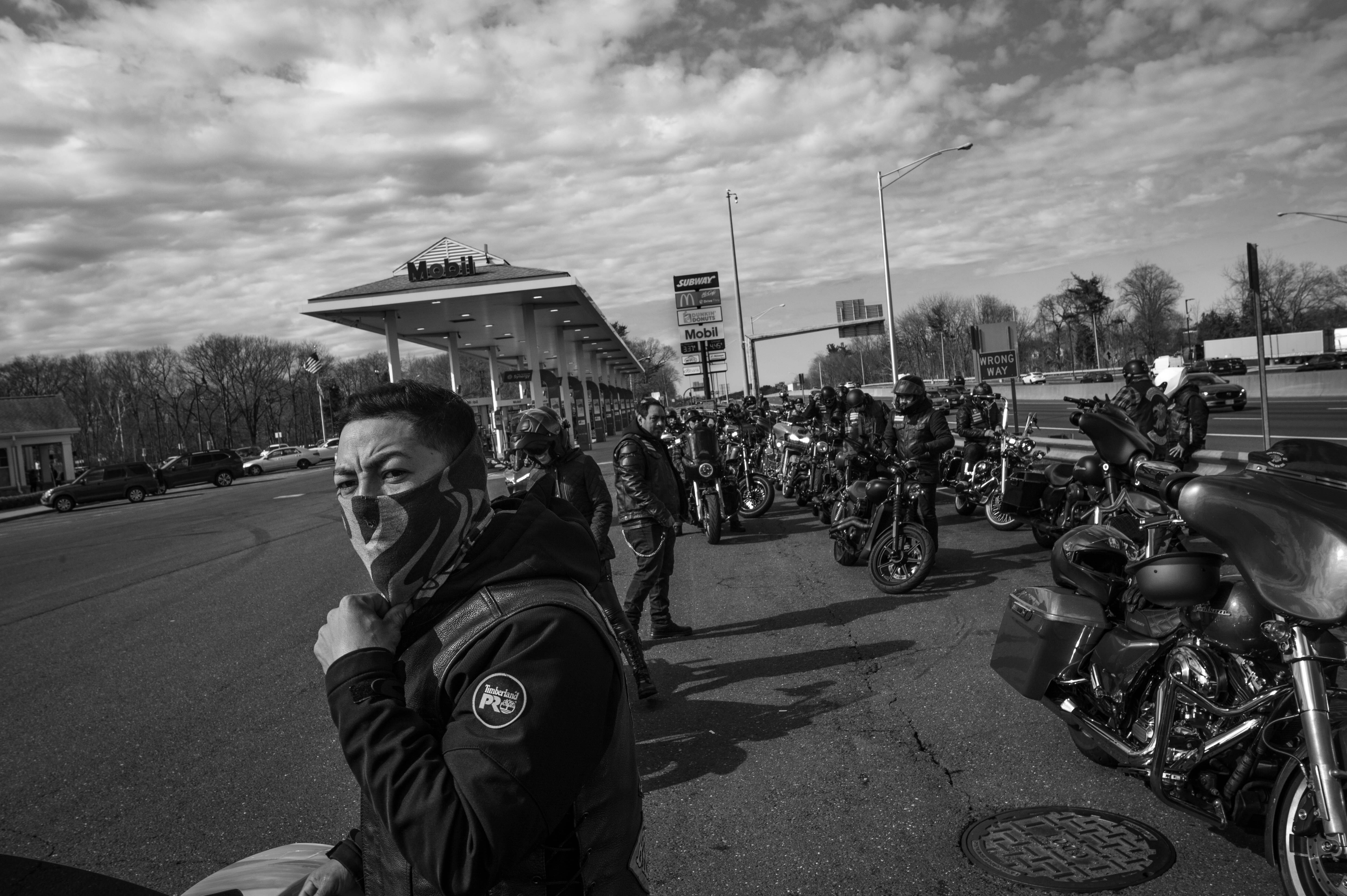 Jossiel Estefes, known as "Onex," stands next to his bike at a gas station in Connecticut during a ride on March 17, 2024.