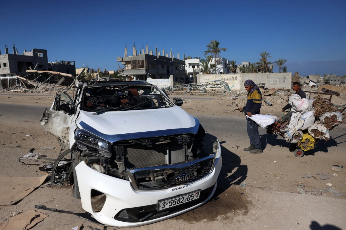 People check a car hit by an Israeli strike in Khan Yunis in the southern Gaza Strip on Saturday. Five people were reported killed, including three World Central Kitchen workers, Gaza's health ministry said.