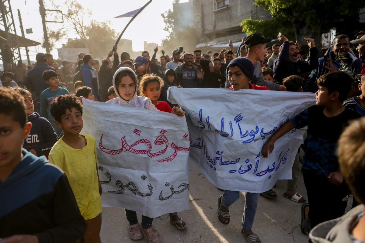 Children carry signs in Arabic that read, 'We refuse to die,' during a rally calling for an end to the war, in Beit Lahia, in the northern Gaza Strip, on Wednesday.