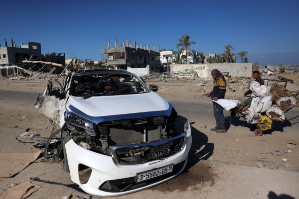 People check a car hit by an Israeli strike in Khan Yunis in the southern Gaza Strip on Saturday. Five people were reported killed, including three World Central Kitchen workers, Gaza's health ministry said.