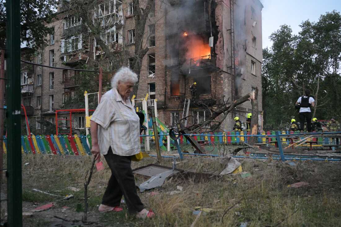 Bir kadın, 2 Temmuz 2026 Perşembe günü Ukrayna'nın Kiev kentinde düzenlenen Rus füze saldırısının ardından yanan bir apartmanın önünden geçiyor.