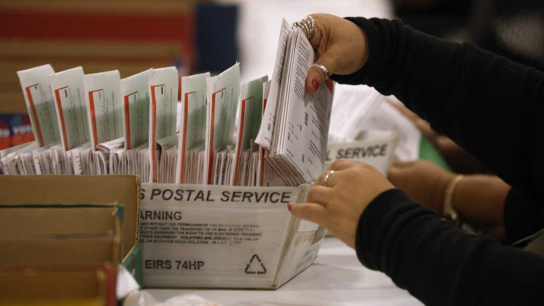 An election worker processes mail-in ballots in June in Industry, Calif.