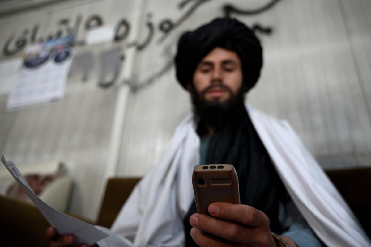 Taliban staff used to rely on smartphones. After a ban was announced, they're using feature phones — also known as 'dumb phones' — which do not have a screen and are designed for calls and texts. This Taliban administrator is using such a phone at the Department of Information and Culture building in Kandahar.
