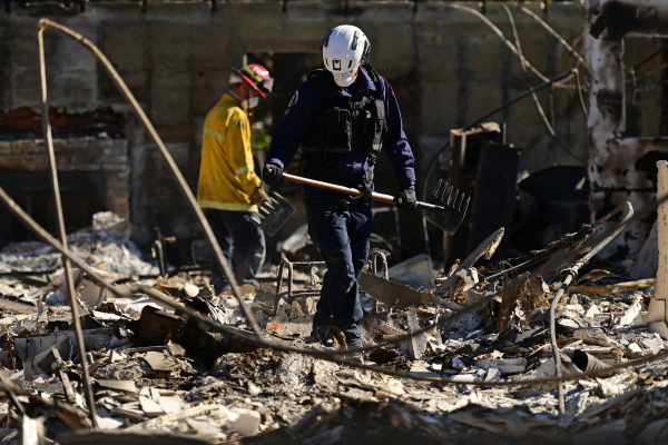 Regional Urban Search and Rescue Task Force (RTF) in Marin County, Calif., and firefighters from Santa Clara County, Calif., comb through the ruins of a house searching for victims, in Altadena, Calif., on Tuesday.