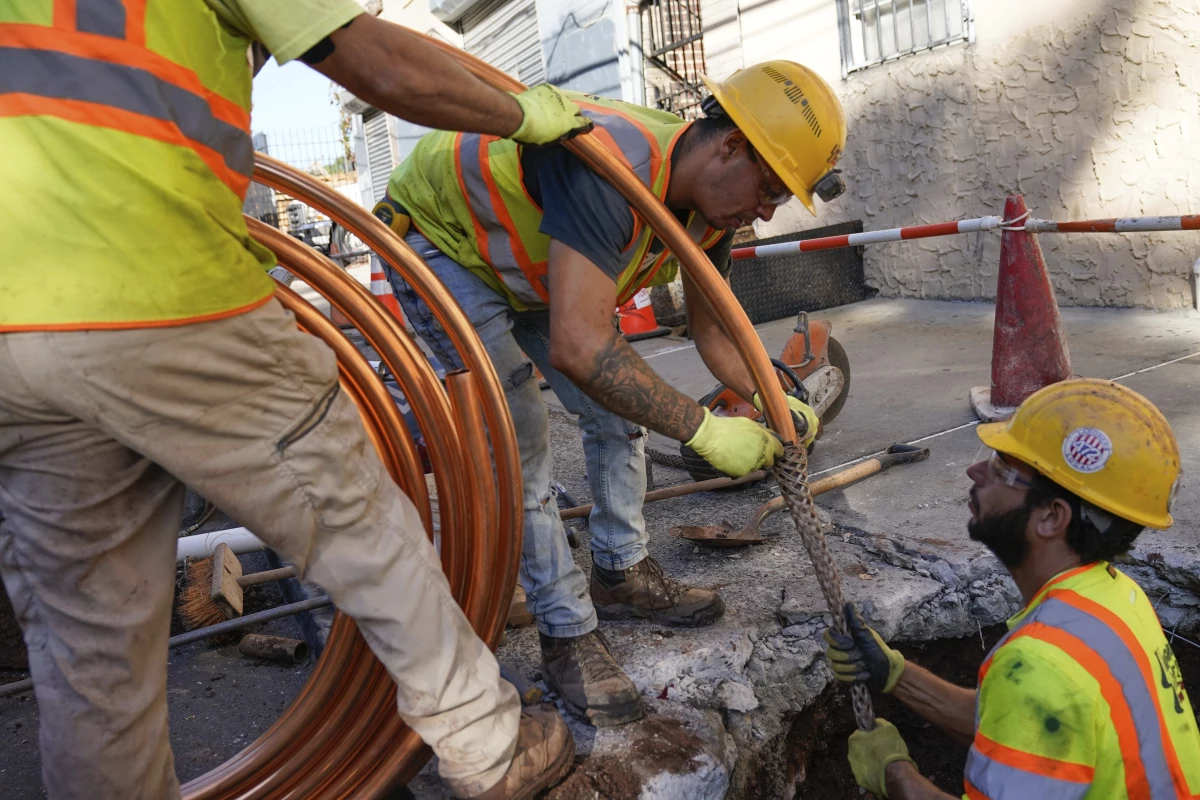 Workmen prepare to replace older water pipes with a new copper one in Newark, N.J., on Oct. 21, 2021.