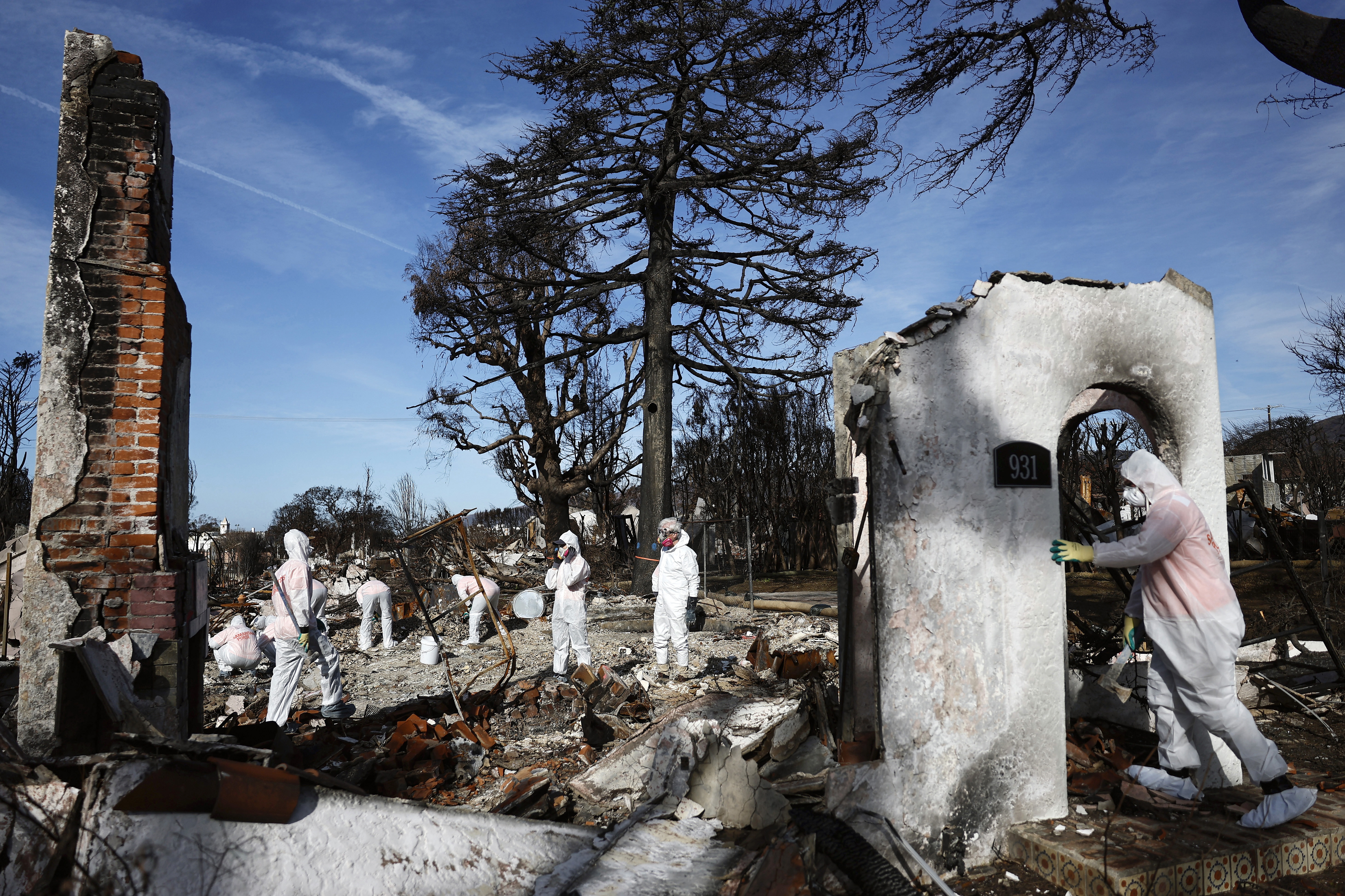 Volunteers help a homeowner search for personal items in the remains of a home that burned in the Palisades Fire in January in Pacific Palisades, California.