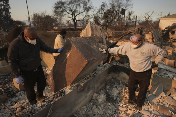 Kenneth Snowden, left, surveys the damage to his fire-ravaged property with his brother Kim, center, and Ronnie in the aftermath of the Eaton Fire on Friday, Jan. 10, 2025, in Altadena, Calif.