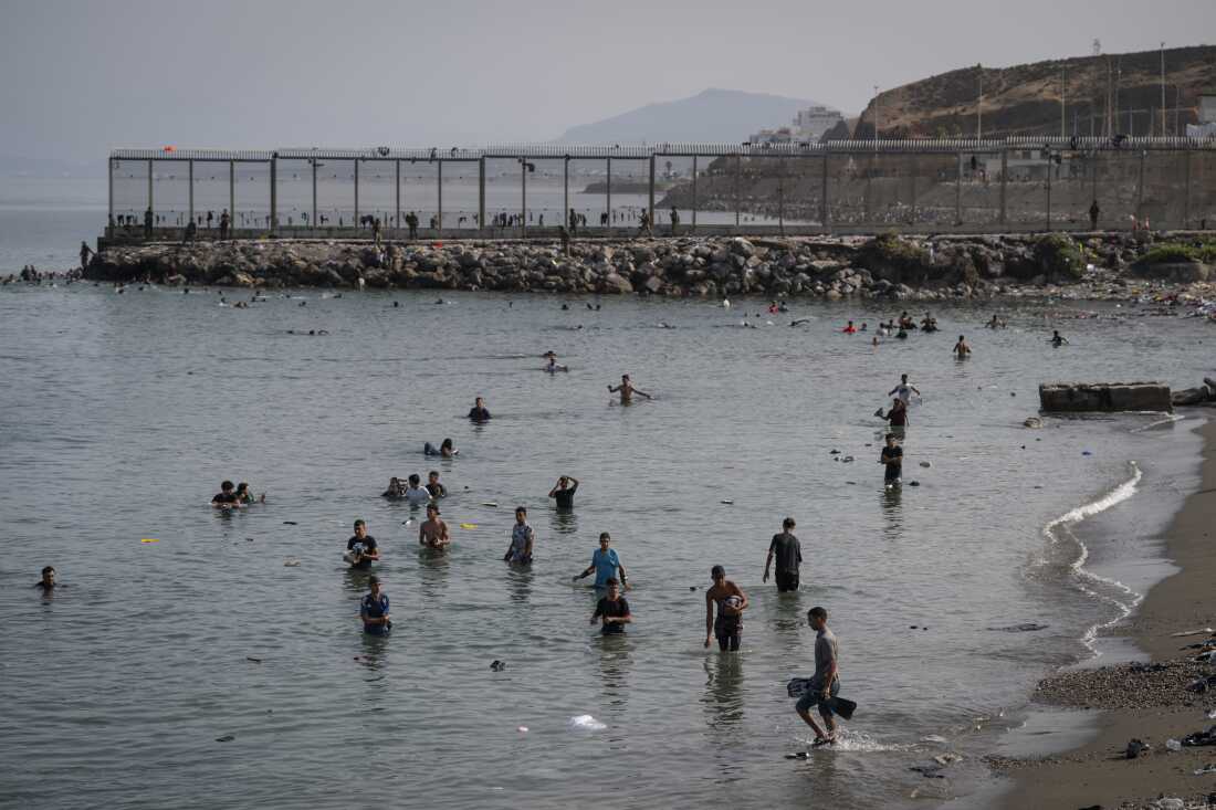 Migrants arrive on Tarajal beach after crossing the border between Spain and Morocco on Friday in Ceuta, Spain. Spain's interior ministry has said it's deploying 60 members of the armed forces and an additional 30 Guardia Civil officers to Ceuta after tens of thousands of migrants entered the Spanish enclave in North Africa on Thursday.