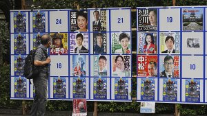 A person looks at an election poster board for Tokyo gubernatorial election Monday, July 1, 2024, in Tokyo.