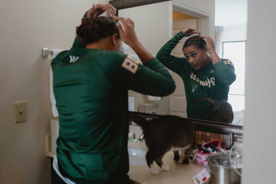 Sabrina Robinson of the Boston Hunters fixes her hair in her hotel room before a social outing with fellow players in the Women's Pro Baseball League. Springfield, IL, July 30, 2026.