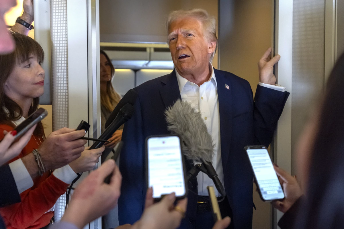 President Donald Trump speaks to reporters aboard Air Force One as he travels from Las Vegas to Miami, on Saturday.
