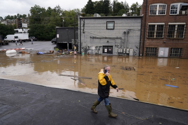 A man walks near a flooded area near the Swannanoa river in the aftermath of Hurricane Helene on Friday, in Asheville, N.C.