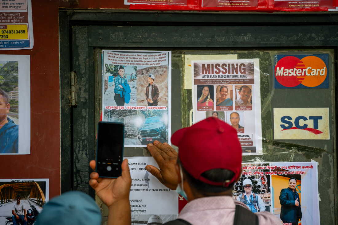 More than 5,600 people are still missing following the catastrophic flash floods in Nepal. The board in the photograph is covered with pictures of some of the missing in Devighat.