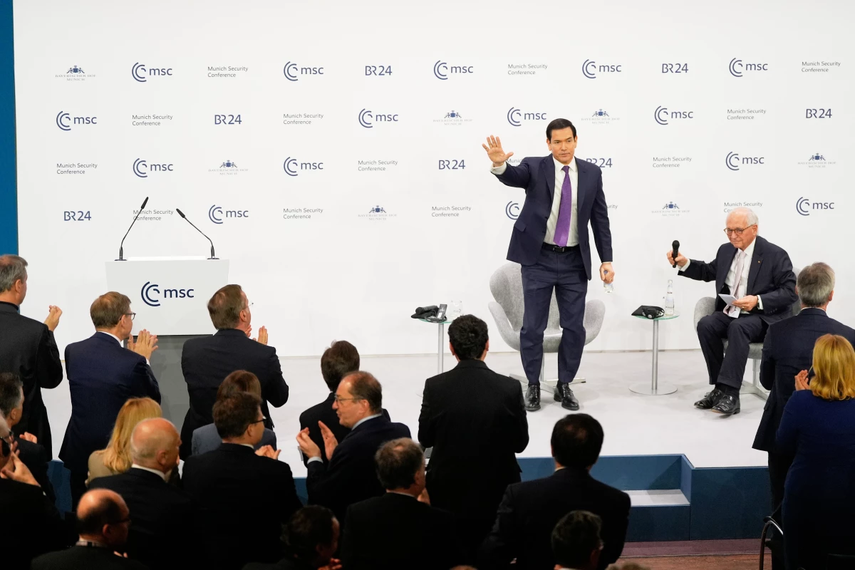 U.S. Secretary of State Marco Rubio waves, next to Chairman of the Munich Security Conference Wolfgang Ischinger, as he gets a standing ovation after his speech at the Munich Security Conference in Munich, Germany, on Saturday.
