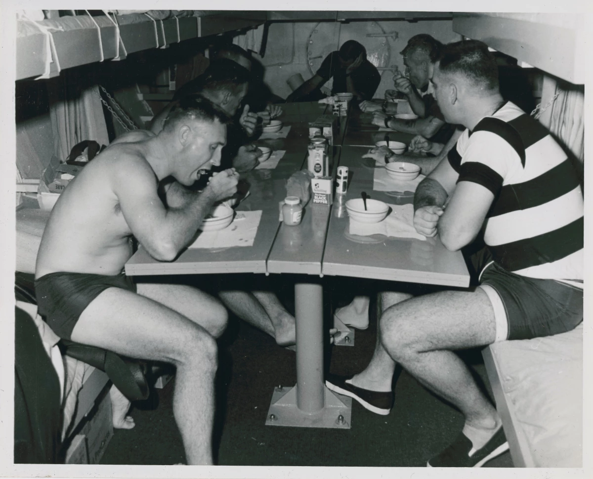 Aquanauts eat a meal inside the Sealab II habitat.