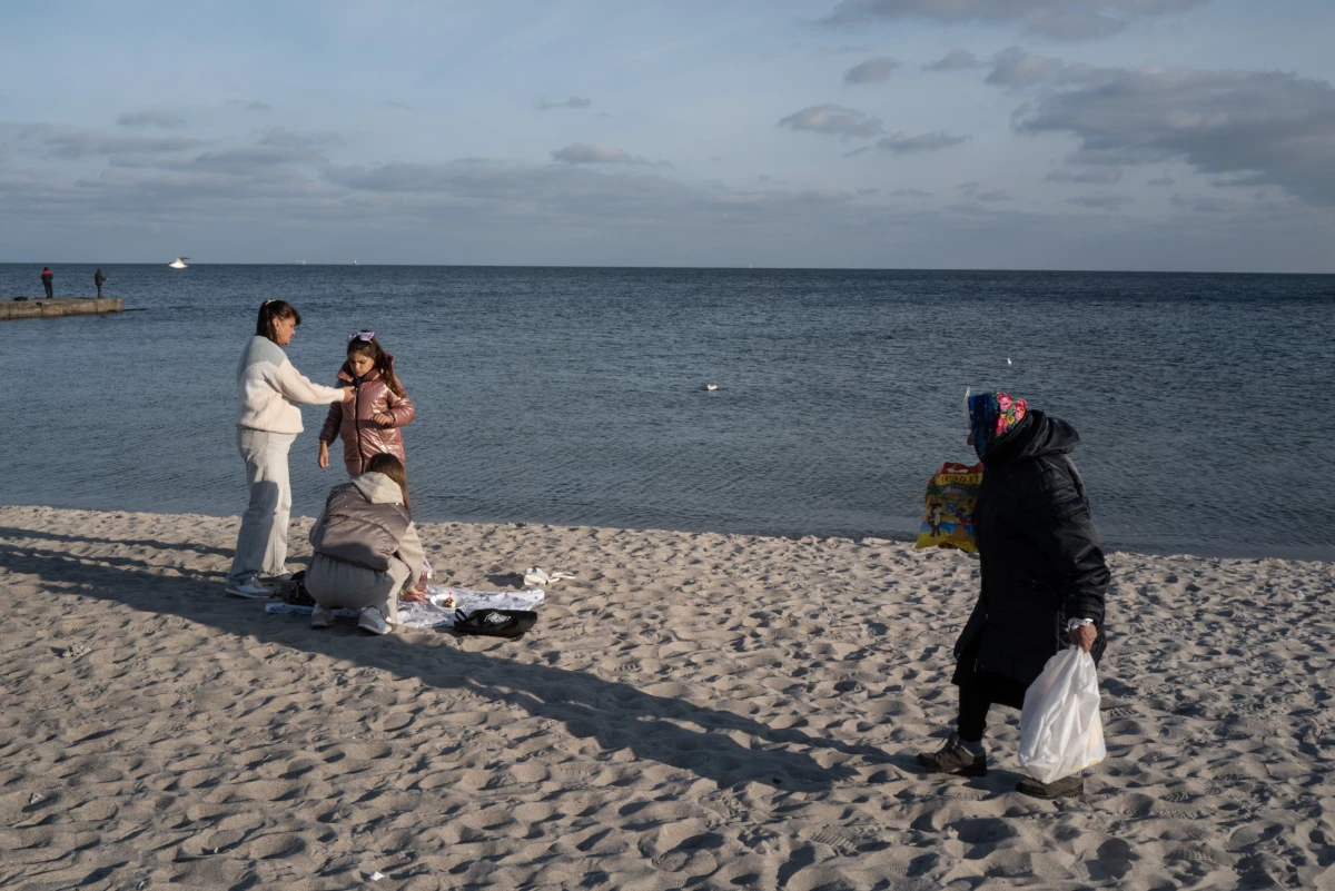 People enjoy a mild fall afternoon on a Black Sea beach in Odesa, Ukraine, on Oct. 27, 2024. The region comes under frequent aerial attack by Russians who launch missiles from the nearby Crimean Peninsula and ships in the Black Sea.