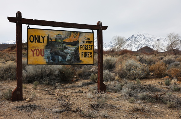A Smokey the Bear forest fire prevention sign stands in front of snow blanketing the Sierra Nevada mountains after recent storms increased the snowpack on February 23, 2024 near Bishop, California. (Photo by Mario Tama/Getty Images)