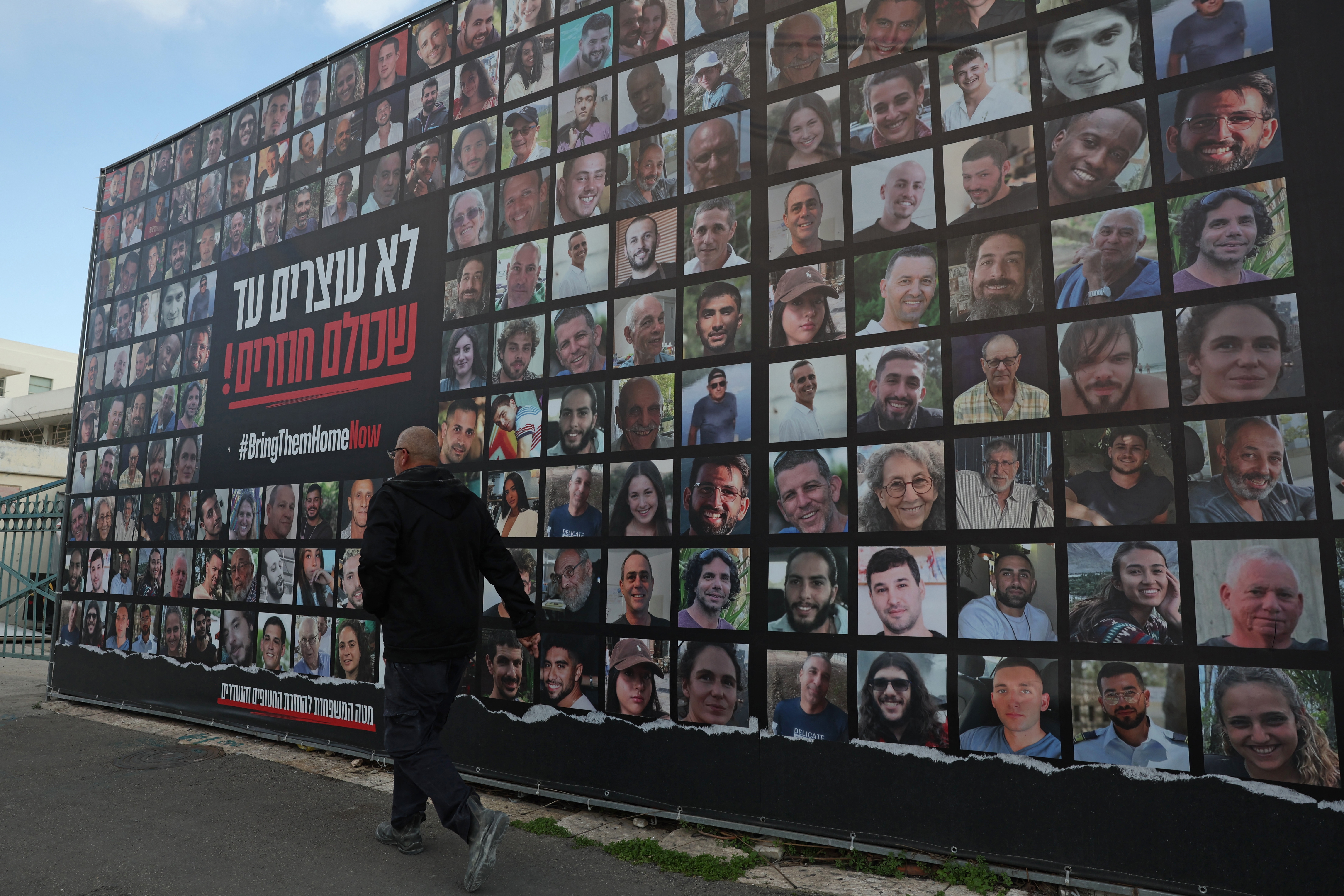 A man walks past a billboard bearing the portraits of Israeli hostages held in the Gaza Strip since the Oct. 7, 2023, attacks by Hamas-led militants, in Jerusalem on Monday, as the country marked the 500th day since their abduction.