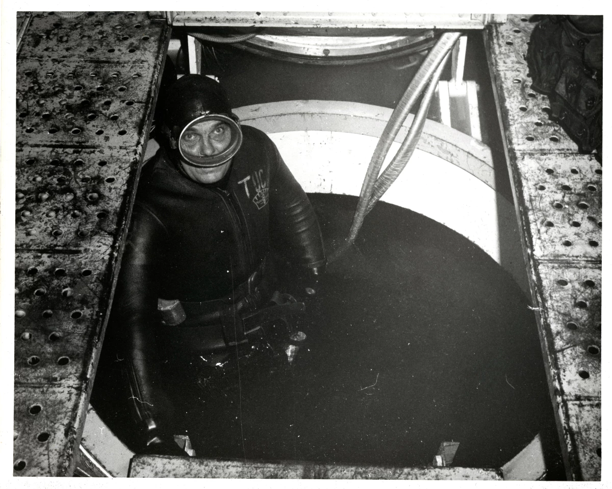 Aquanaut Cyril Tuckfield stands in an open hatch inside the Sealab II habitat.