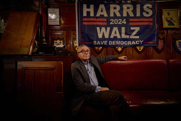A patron sits beneath a Kamala Harris election flag as he watches coverage of the US presidential election at Harry's Bar during an electoral night event following the US presidential election, in Paris on Tuesday.