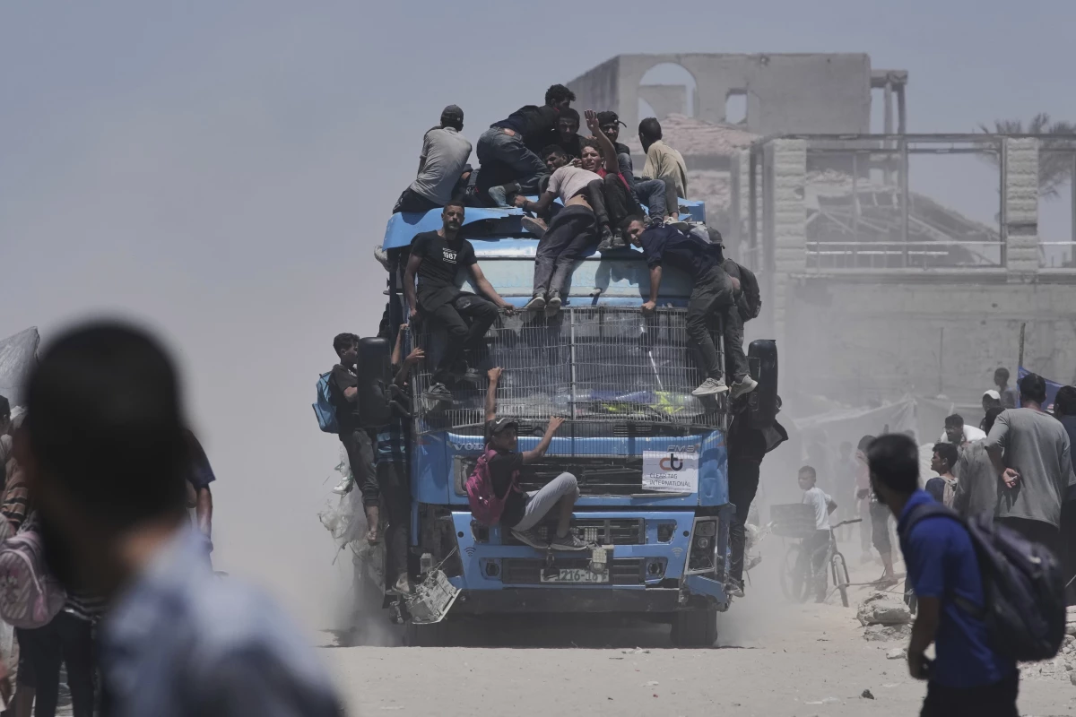 Palestinians hold onto an aid truck returning to Gaza City from the northern Gaza Strip on Tuesday.