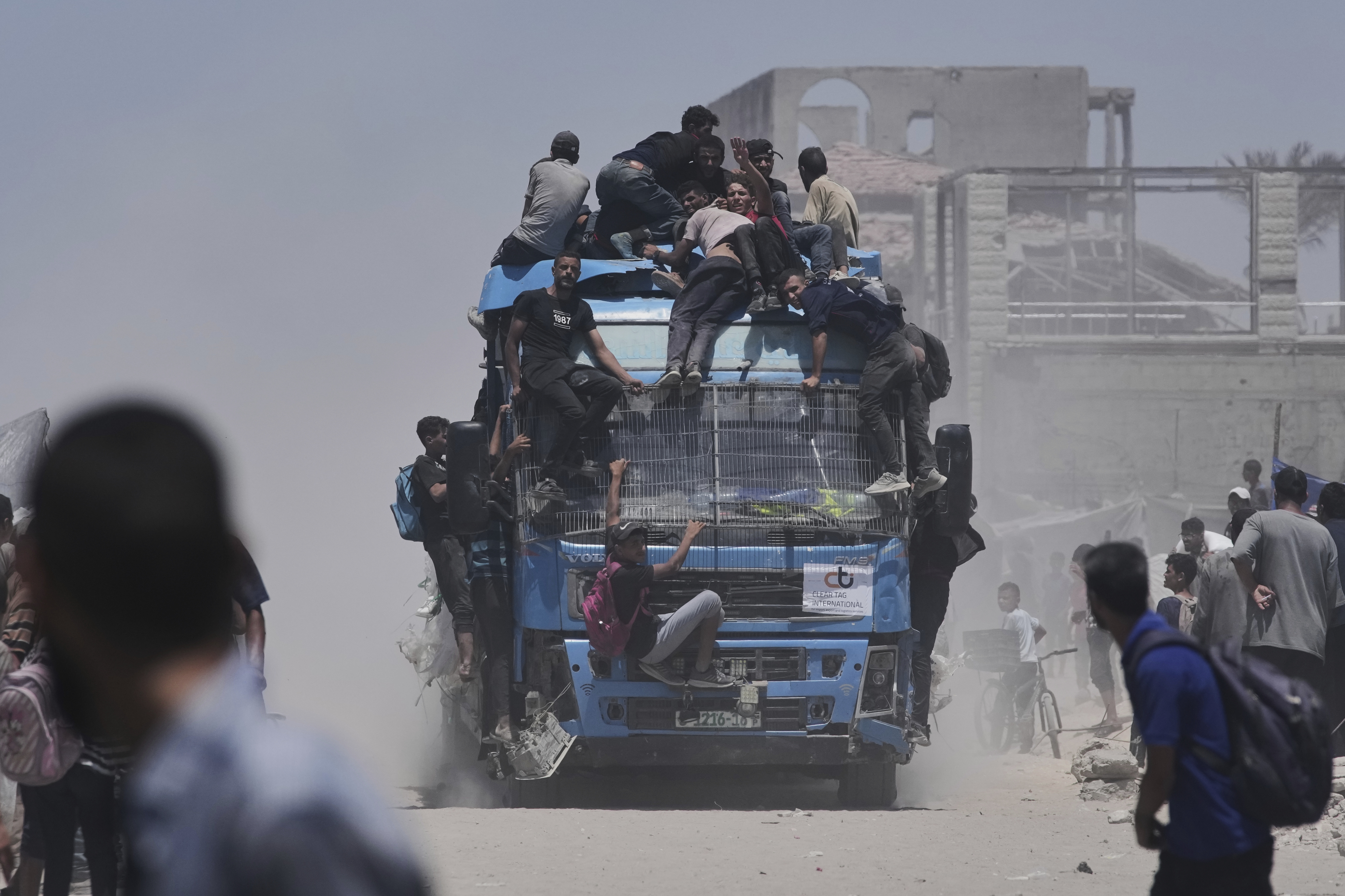 Palestinians hold onto an aid truck returning to Gaza City from the northern Gaza Strip on Tuesday.