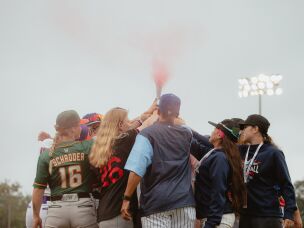 WPBL teams' captains and the league's commissioner, Justine Siegal, pass a torch to youth representatives of Baseball For All, a gender equity initiative to support girls in baseball, in Springfield, Ill., on Saturday, Aug. 1.