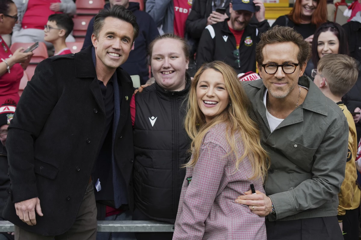 Wrexham co-owners Ryan Reynolds (from right), his wife Blake Lively and Rob McElhenney pose with fans before the English League One soccer match between Wrexham and Charlton Athletic at the Racecourse ground in Wrexham, Wales, on April 26, 2025.