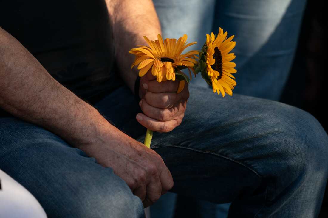 A mourner holds flowers during Munder's funeral, Aug. 22.