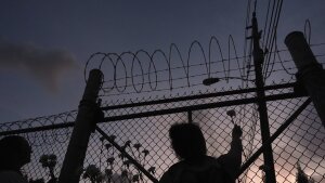 People place flowers on a fence outside Krome Detention Center in Miami in May 2025, during a vigil to recognize people who have died in U.S. Immigration and Customs Enforcement custody as well as those affected by mass deportations.