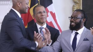Shiloh Jordan, right, who was among the people receiving a pardon for a misdemeanor marijuana conviction years ago, greets Maryland Gov. Wes Moore at a news conference in Annapolis, Md., on June 17 when Moore announced more than 175,000 pardons. Maryland Attorney General Anthony Brown is center.