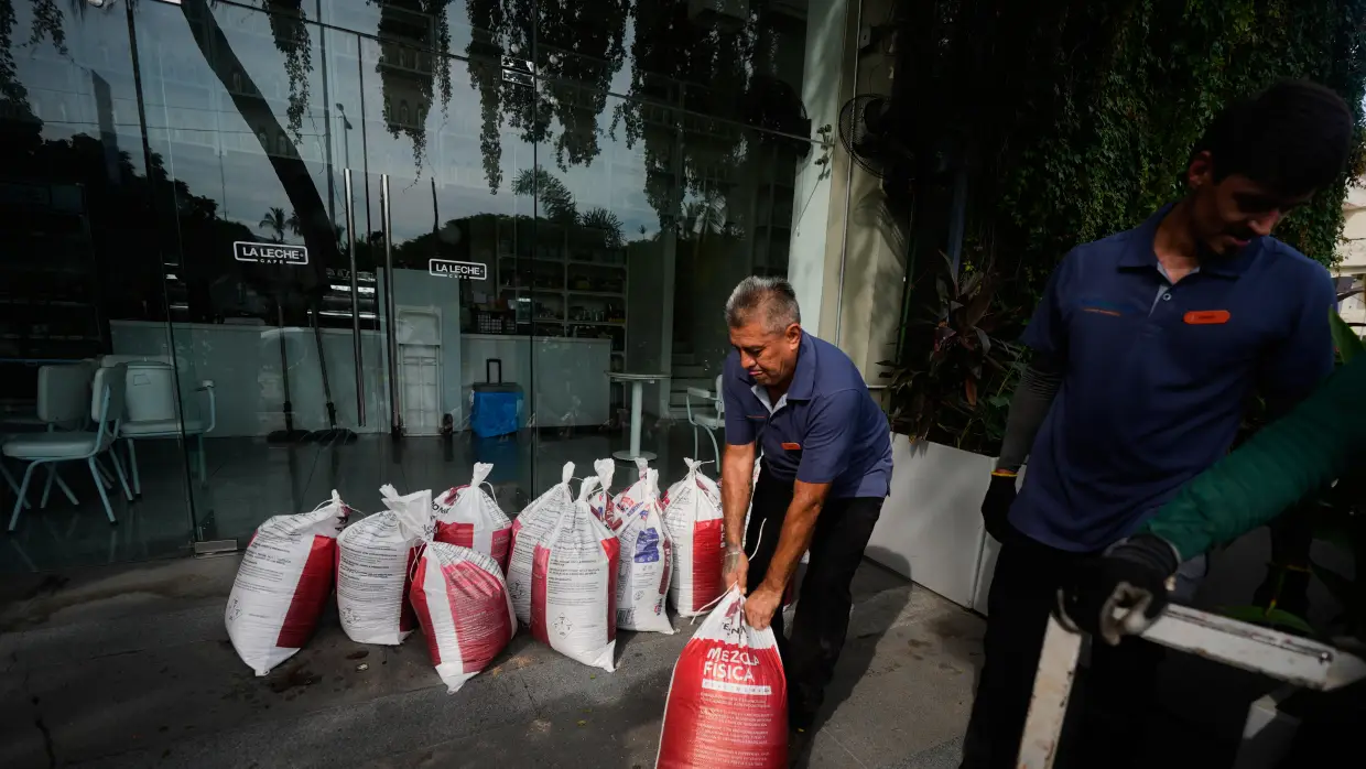 Workers place sandbags outside a restaurant as Hurricane Simon approaches Puerto Vallarta, Mexico, Saturday, Oct. 10, 2026.