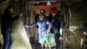 A policeman helps an elderly woman to walk out from a residential building damaged by a Russian airstrike in Zaporizhzhia, Ukraine, on Saturday.