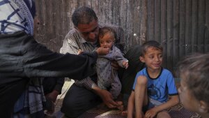 Wedad Abdelaal and her husband Ammar feed their 9-month-old son Khaled, in their tent at a camp for displaced Palestinians in Mawasi Khan Younis, Gaza Strip on Friday.