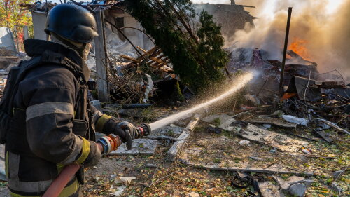 A rescue worker puts out a fire at residential houses destroyed in a Russian strike on Kharkiv, Ukraine, Sunday, Oct. 11, 2026.