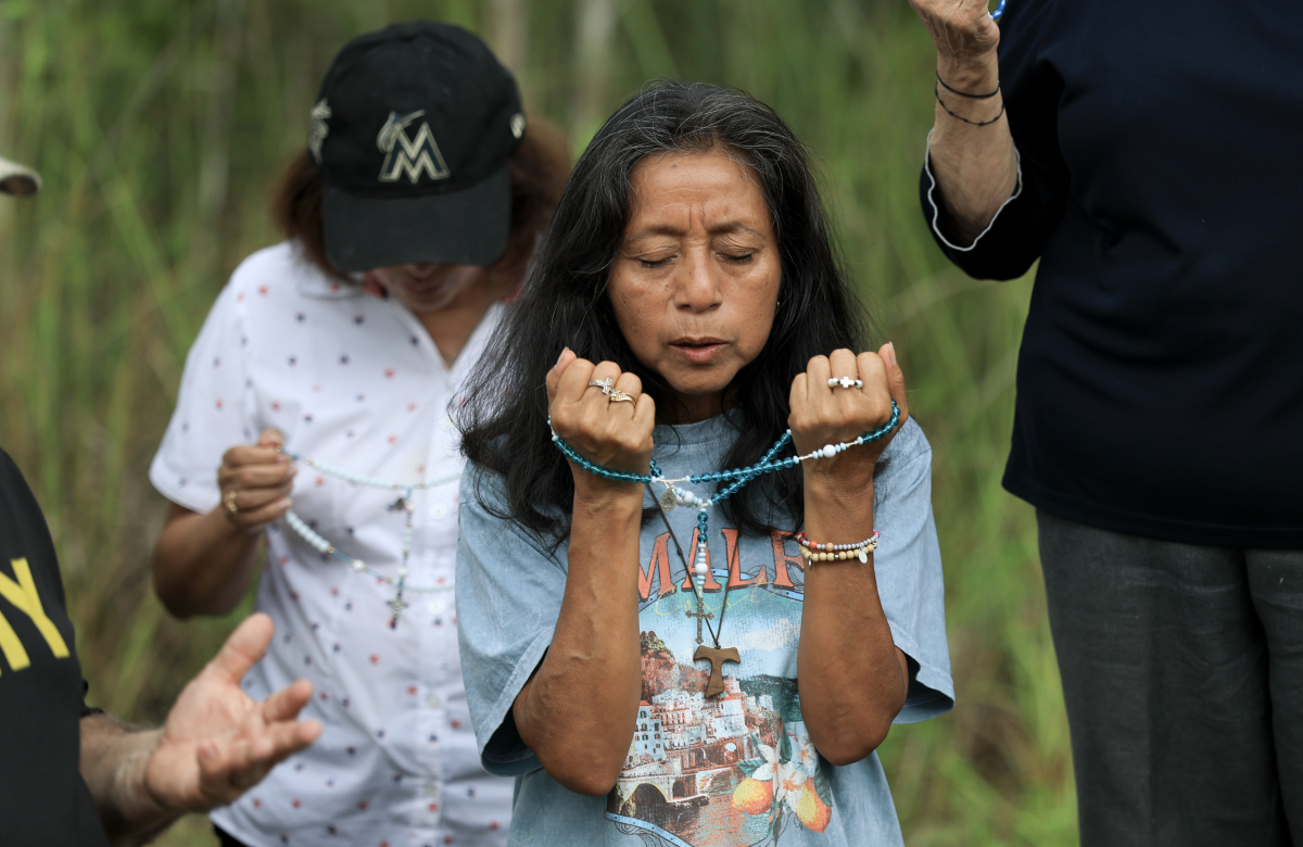 Marina Paz prays near the entrance to 'Alligator Alcatraz' at the Dade-Collier Training and Transition Airport in Ochopee, Fla., on July 12. Paz was praying for those held in the facility.