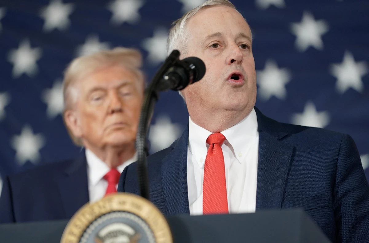 President Donald Trump listens as Michael Whatley, former Republican National Committee Chairman speaks during a visit to the Fort Bragg U.S. Army base on February 13, 2026 in Fort Bragg, North Carolina.
