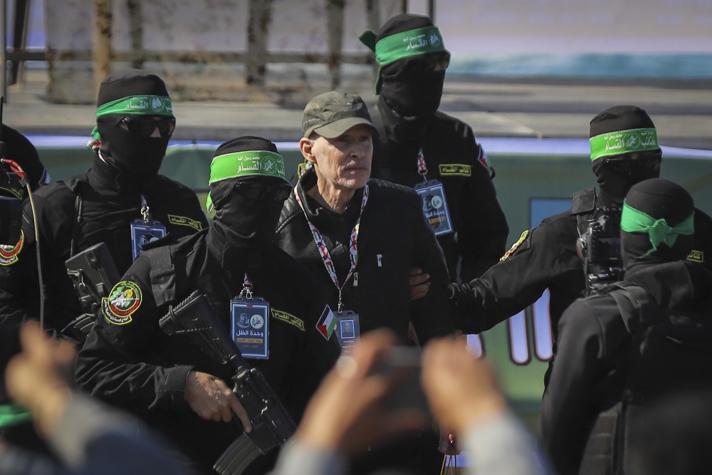 American-Israeli hostage Keith Siegel, 65, is escorted by Hamas fighters as he is handed over to the Red Cross in Gaza City, Saturday Feb.1, 2025. (AP)