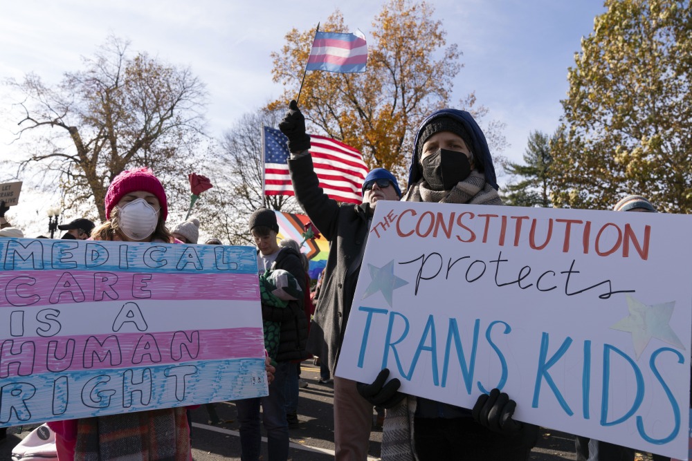 Supporters of transgender rights hold signs as they rally outside the Supreme Court on Wednesday in Washington, D.C., as arguments begin in a case regarding a Tennessee law banning gender-affirming medical care for transgender youth. (Getty Images)