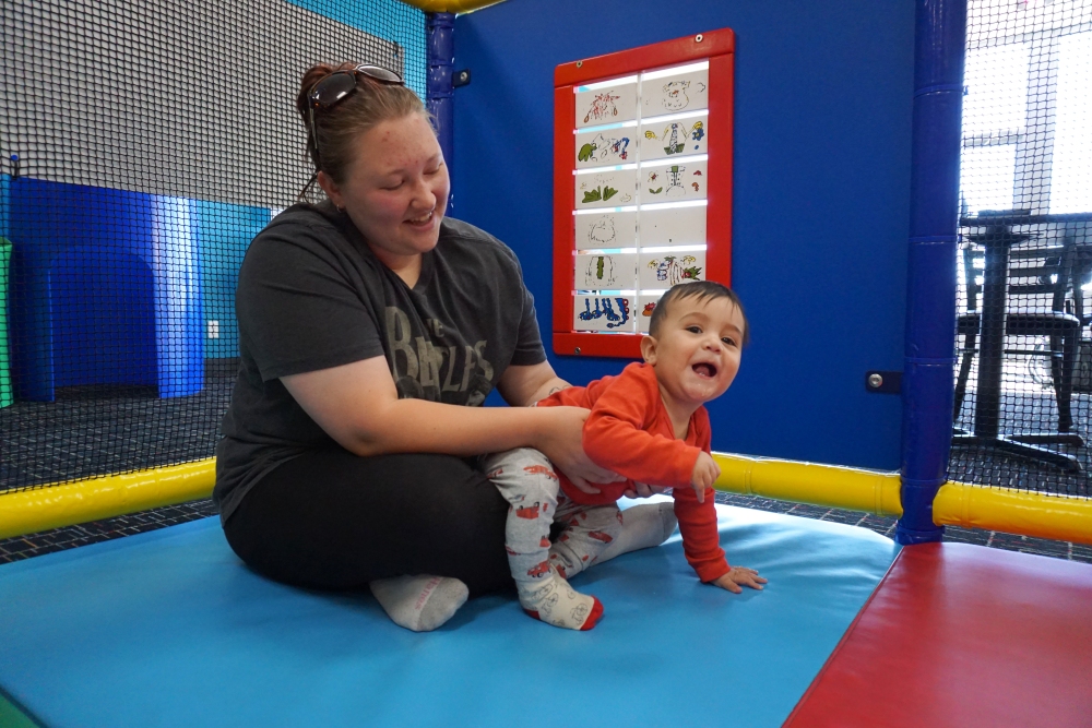 Grace Moreno plays with her 11-month-old toddler at an indoor play center in Cheyenne, Wyo. Months earlier, she thought she'd have multiple kids. But with expenses adding up, six weeks after giving birth, Moreno decided to have her tubes tied. (Mountain West News Bureau&nbsp;)