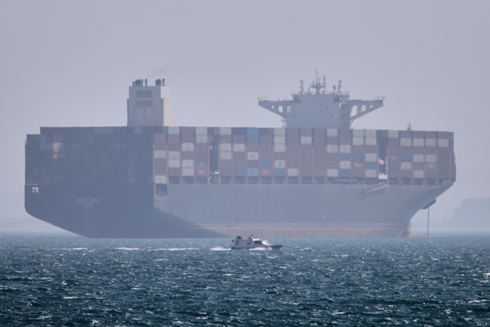 A container ship sits at anchor as a small motorboat passes in the foreground in the Strait of Hormuz off Bandar Abbas, Iran, on May 2. (ISNA via AP)