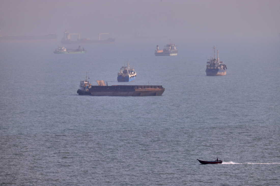 FILE - A small boat sails past cargo ships and other commercial vessels anchored in the Strait of Hormuz off Bandar Abbas, Iran, Wednesday, Aug. 5, 2026. (Amirhosein Khorgooi/ISNA via AP, File)