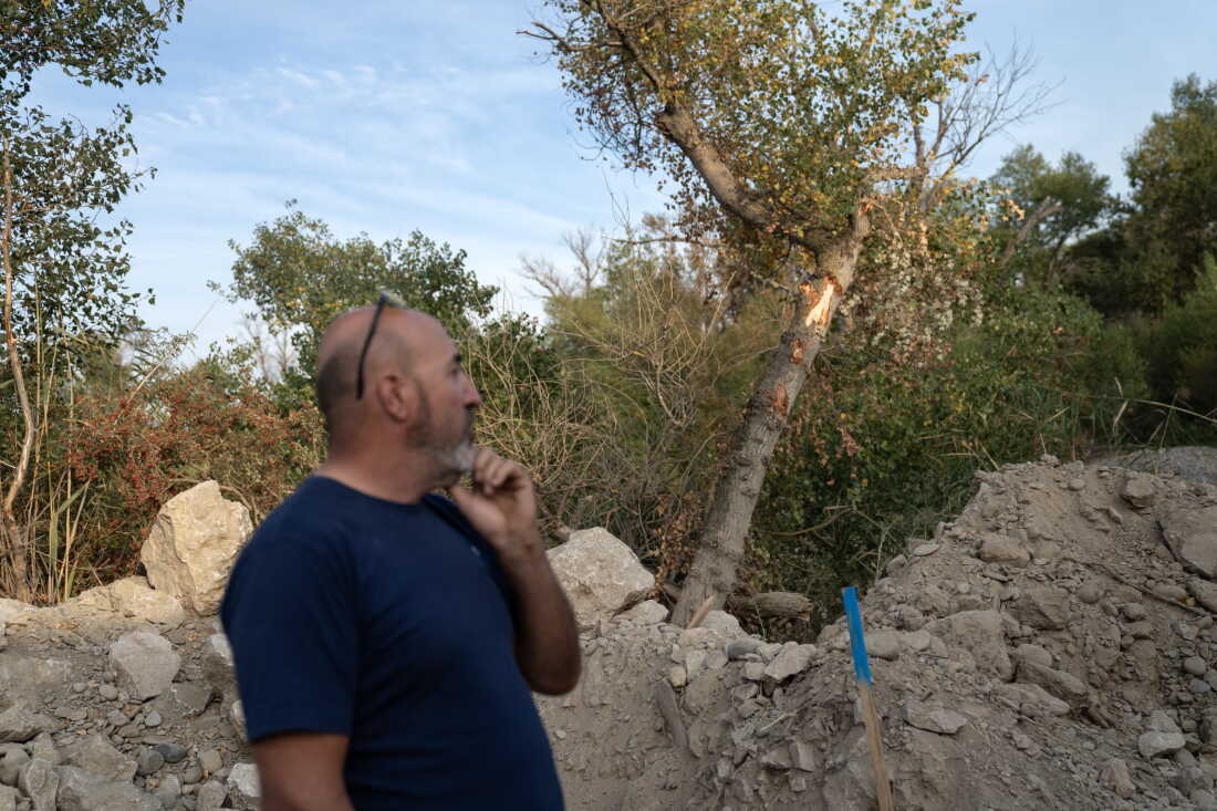 A farmer stands at the edge of a construction site where an outflow pipe will be installed that will carry hot water from a nearby Amazon data center.