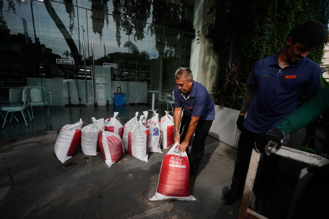 Workers place sandbags outside a restaurant as Hurricane Simon approaches Puerto Vallarta, Mexico, Saturday, Oct. 10, 2026.