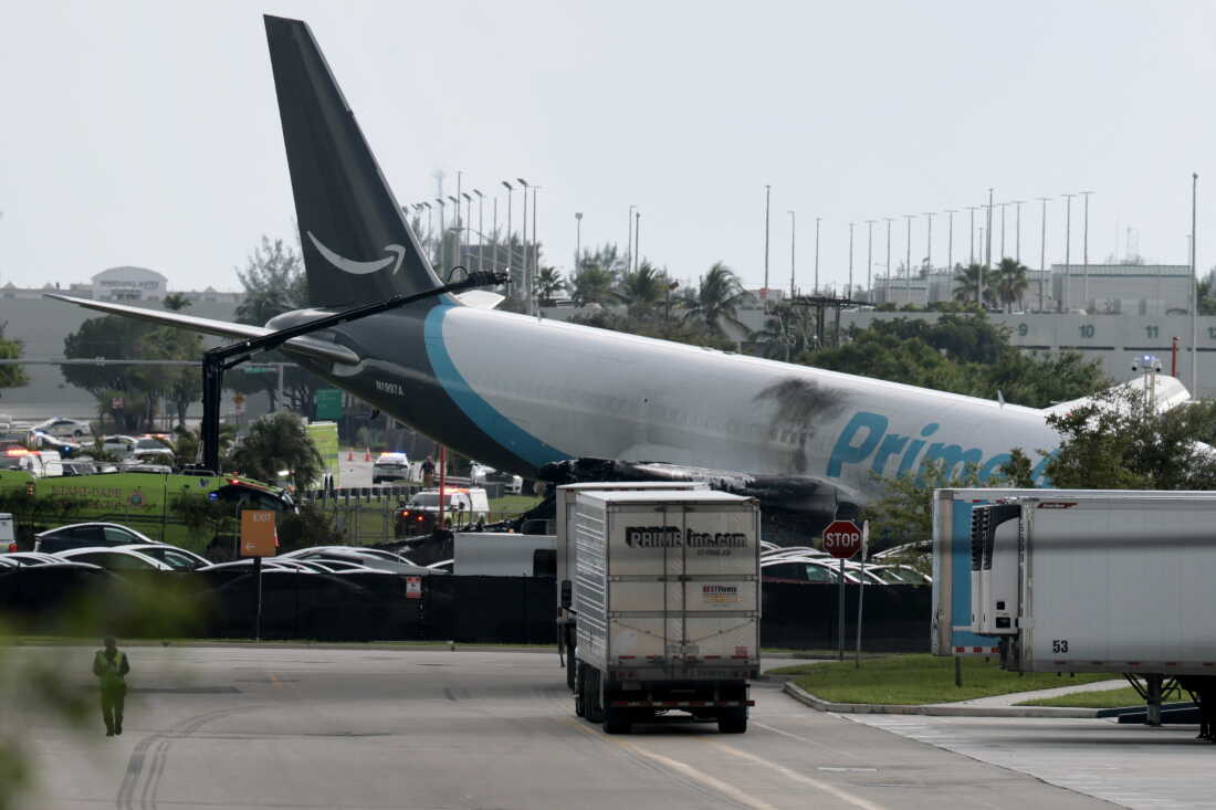 An Amazon cargo plane is seen after it crashed at Miami International Airport on Sunday in Miami, Florida. The Federal Aviation Administration said Prime Air Flight 7598 overran the runway while landing around 2 p.m. ET after departing from San Juan, Puerto Rico.