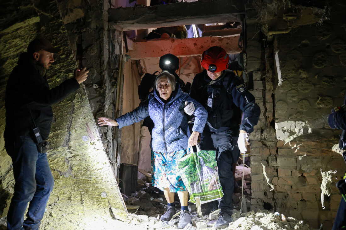 A policeman helps an elderly woman to walk out from a residential building damaged by a Russian airstrike in Zaporizhzhia, Ukraine, Saturday, Oct. 17, 2026. 