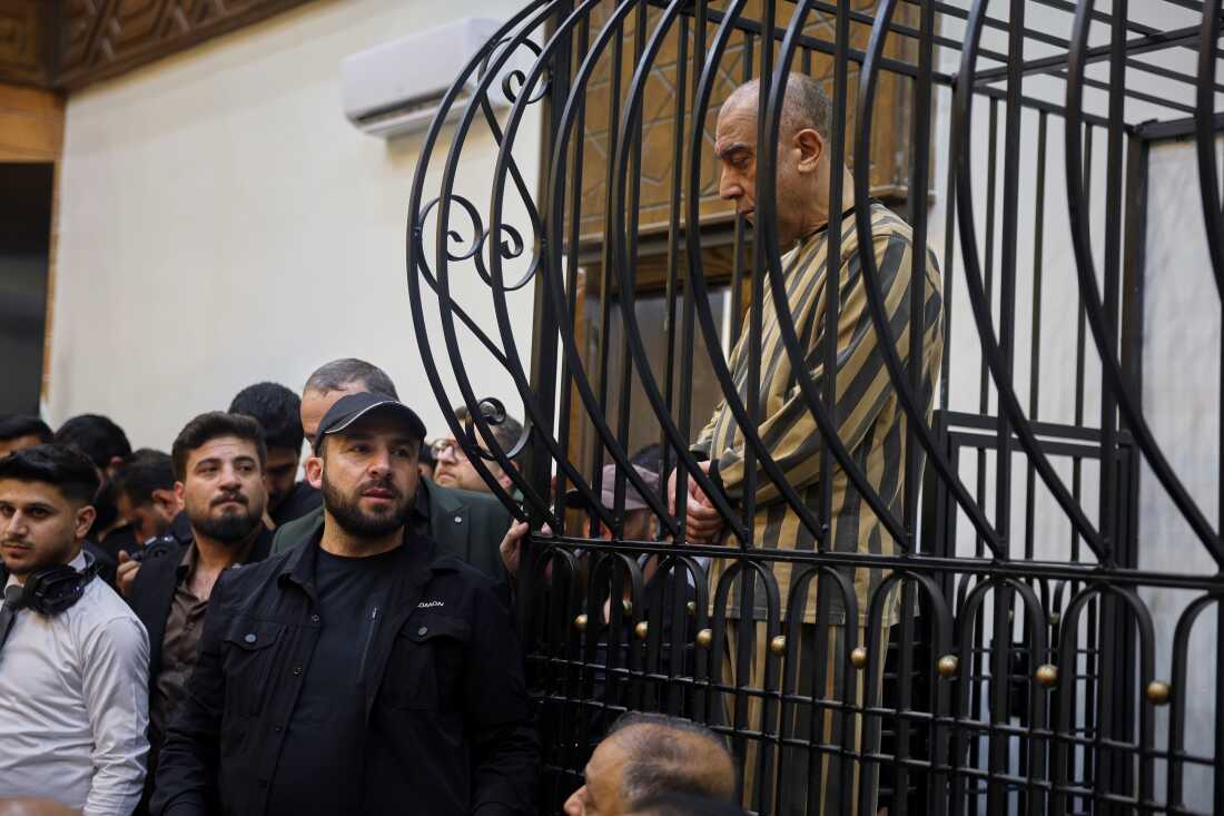 FILE -Atef Najib, former head of the Political Security Branch in the Daraa area during Bashar Assad's rule, sits in the defendants' cage during a trial session at the Palace of Justice in Damascus, Syria, April 26, 2026.